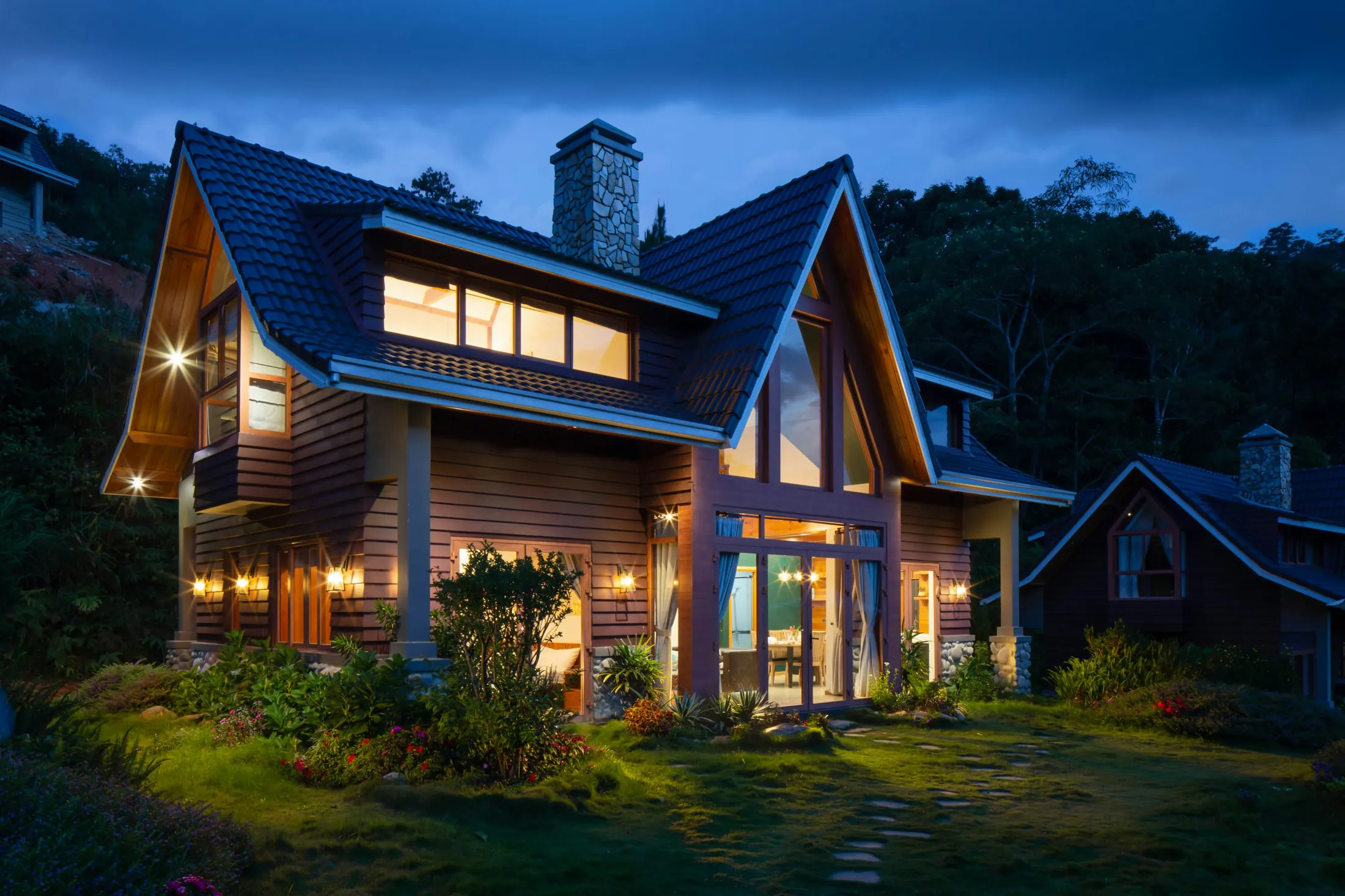 A lake home lit up at dusk among the pines